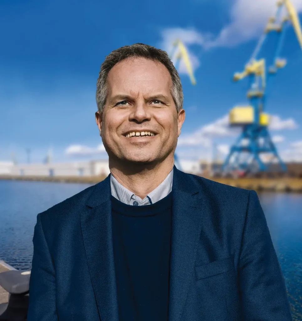 Geschäftsführer Stefan Höller von Verladekränen im Hafen von Wismar bei bei sonnigem Wetter mit blauem Himmel